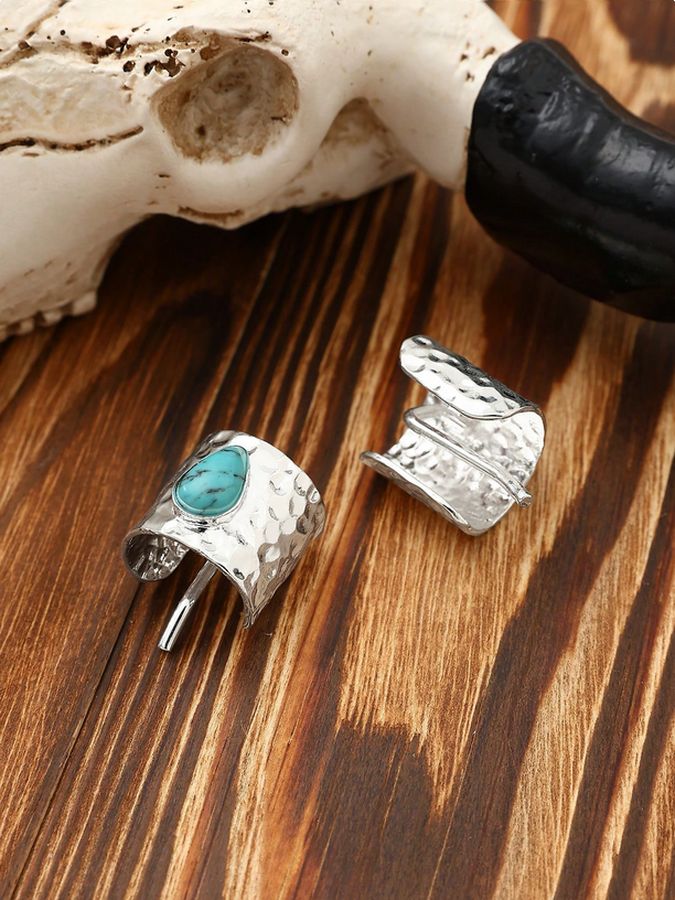 Silver ring with turquoise stone and matching cufflinks on a wooden surface