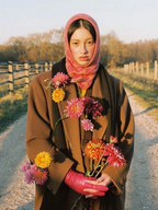 Person holding flowers on a rural road