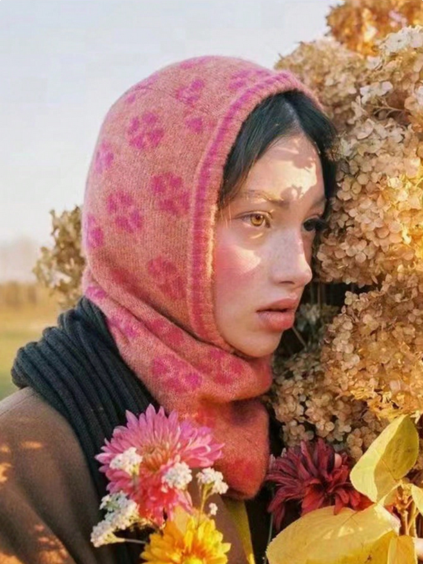 Person wearing a pink floral headscarf with flowers in the foreground