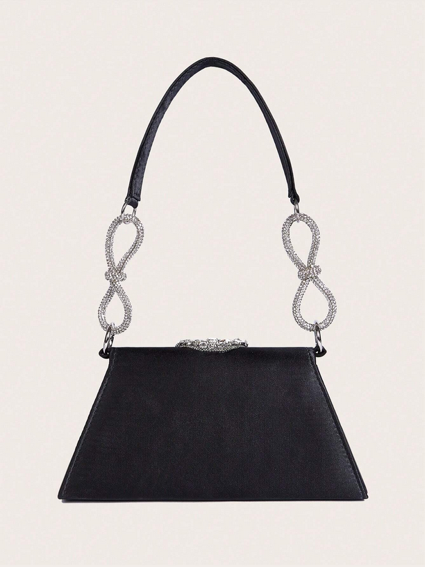 Black handbag with decorative handle on a light gray background