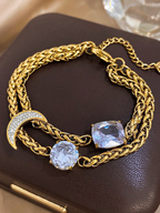 Gold chain bracelet with crystal stones on a dark surface