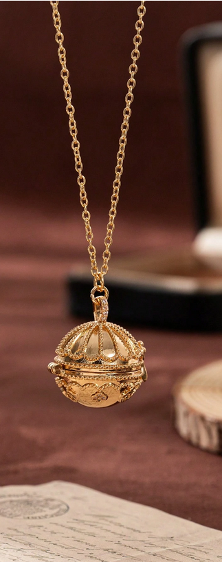 Gold necklace with a decorative pendant on a brown surface
