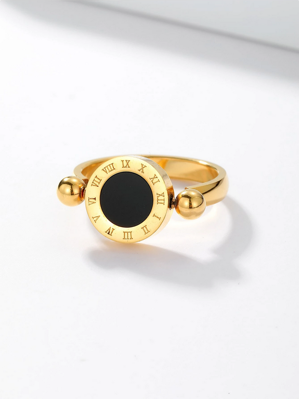 Gold ring with a black center and Roman numeral accents on a white background