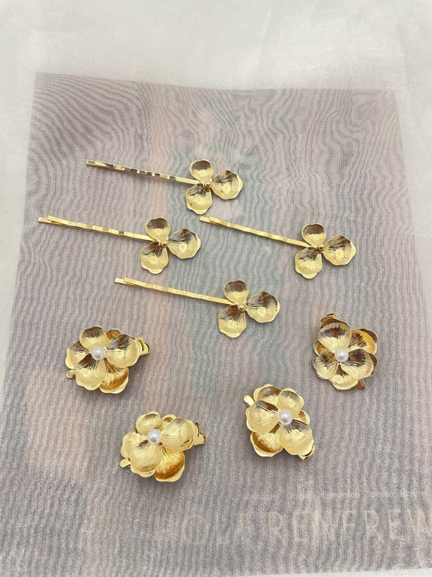 Gold floral hairpins on a textured gray surface