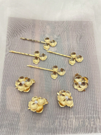 Gold floral hairpins on a textured gray surface
