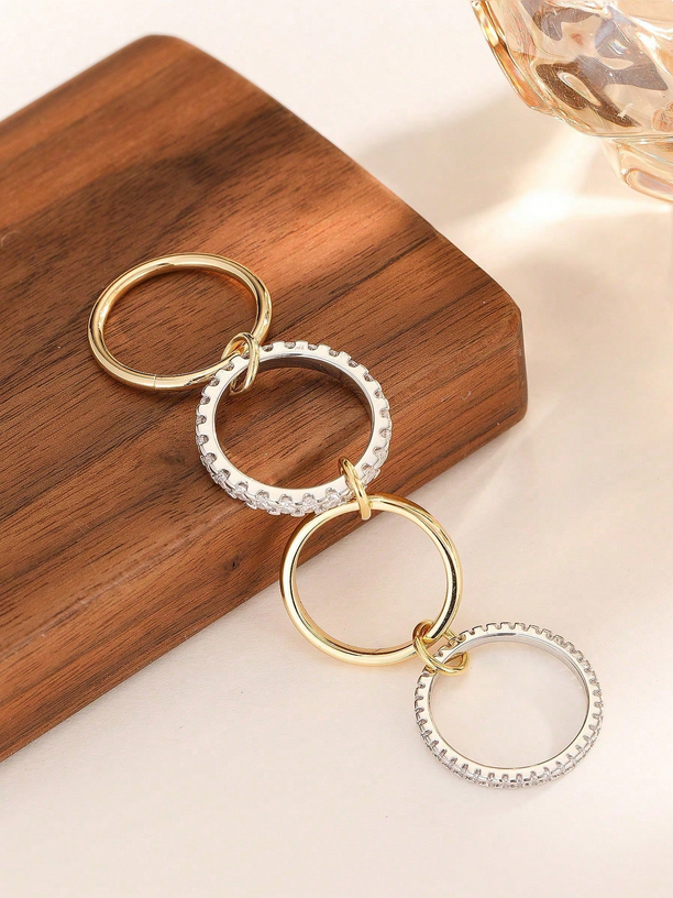 Gold and silver circular keychains on a wooden block with a soft background
