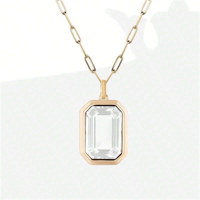 Gold necklace with a clear gemstone pendant on a white background
