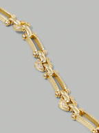 Gold bracelet with heart-shaped charms on a gray background
