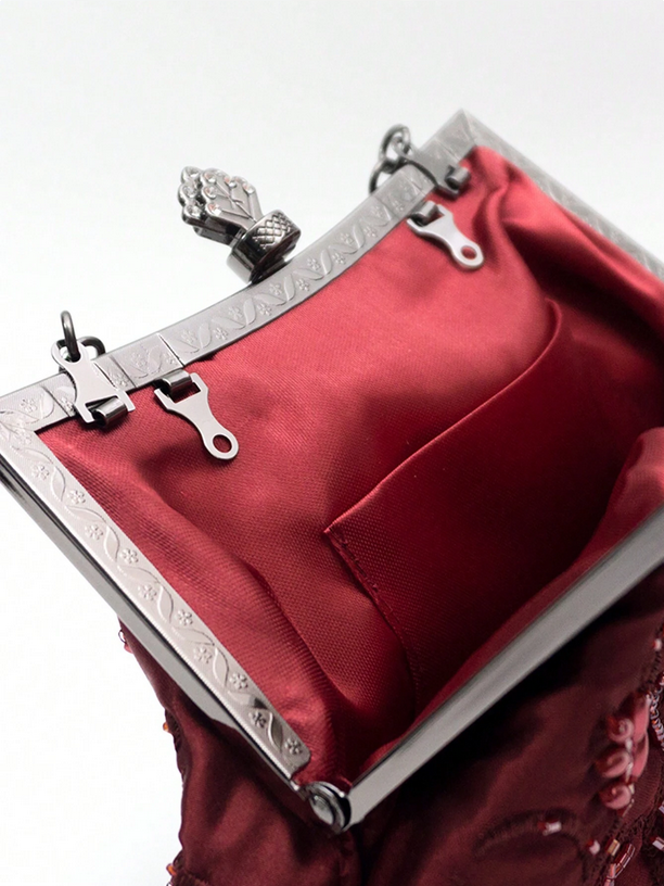 Red handbag with silver frame and clasp on a white background
