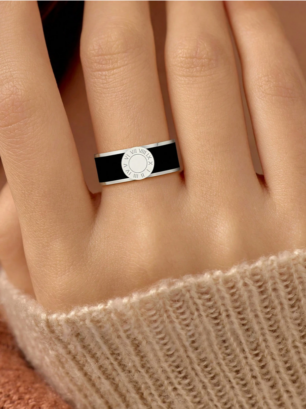 Ring with a black and silver design on a finger