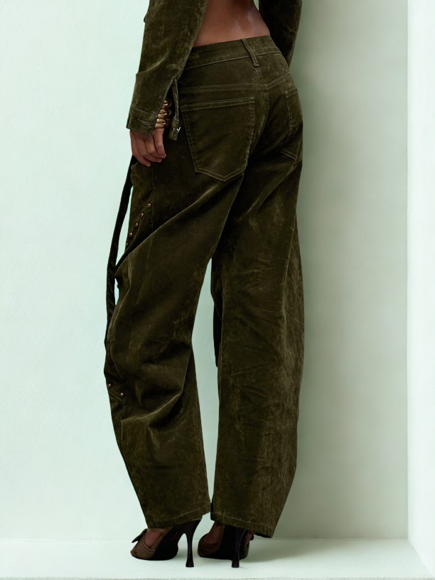 Person wearing olive green corduroy pants with a plain background