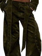 Dark green corduroy pants with decorative studs on a white background