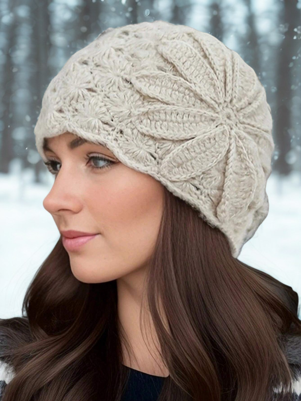 Woman wearing a beige knitted hat in a snowy forest setting